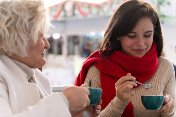 Women enjoying hot drinks at christmas market
