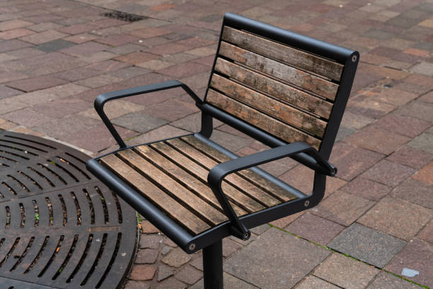 istock Urban park bench on a cobblestone path during midday 2190417638