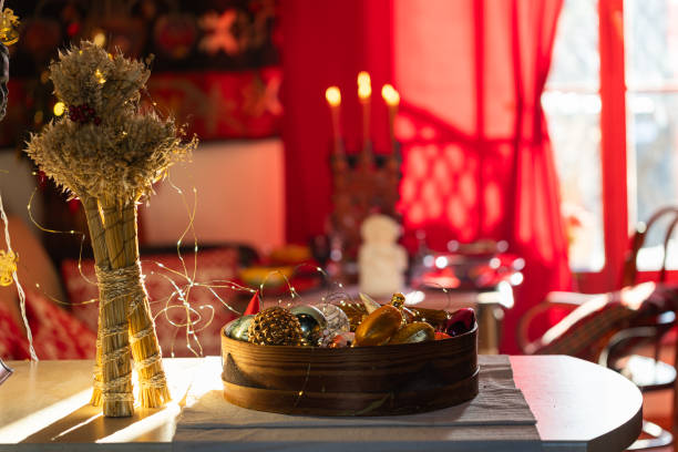 A man enjoys a serene river view on a wooden deck with a dining table set for a meal. The warm glow of lanterns enhances the sunset ambiance, creating a peaceful atmosphere.