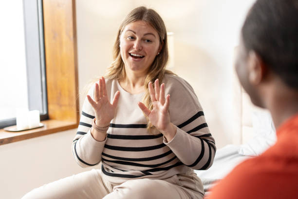 istock Beautiful woman with hearing disability making gestures for man in room 2190425109