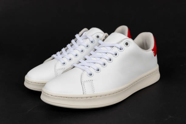 istock Pair of new white sneakers on black background 2190426083