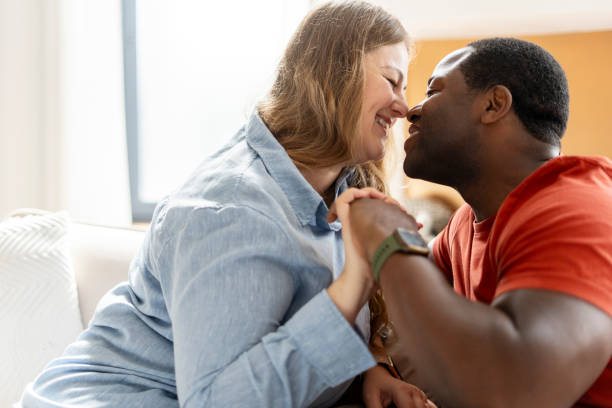 istock Happy romantic multiracial couple holding hands, looking each other, resting at home 2190426318
