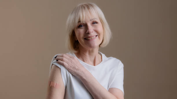 istock Coronavirus immunization infection covid19 vaccination happy vaccinated senior lady mature woman posing with adhesive medical plaster on arm after antivirus injection support against pandemic disease 2190429925