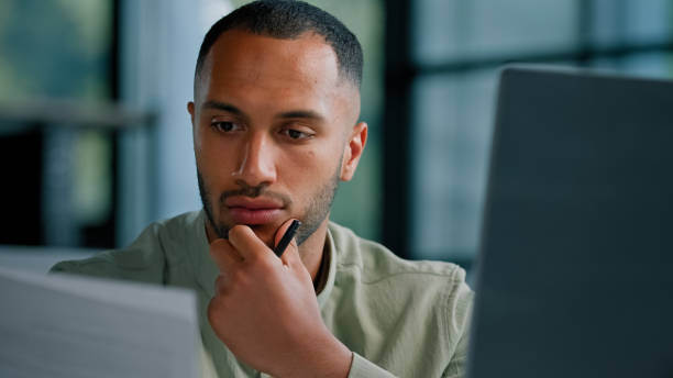 istock Serious pensive thinking African ethnic businessman boss auditor checking corporate paperwork correspondence male entrepreneur reading documents think check problem analyzing financial papers audit 2190430466