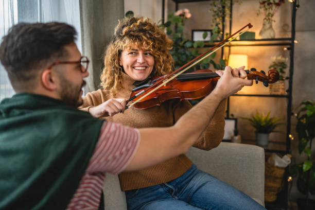 istock boyfriend teach girlfriend how to play violin practice at home 2190430647