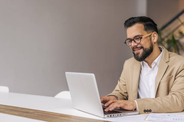 istock Successful businessman in modern office working on laptop 2190431124