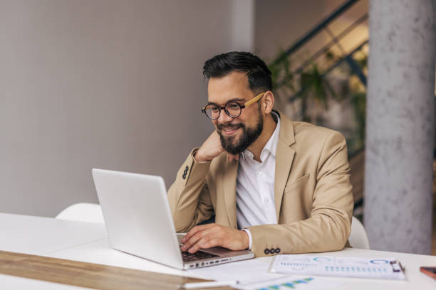 istock Successful businessman in modern office working on laptop 2190431232