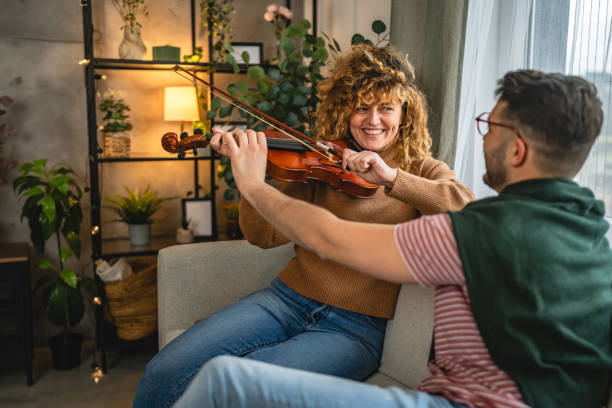 istock boyfriend teach girlfriend how to play violin practice at home 2190431996