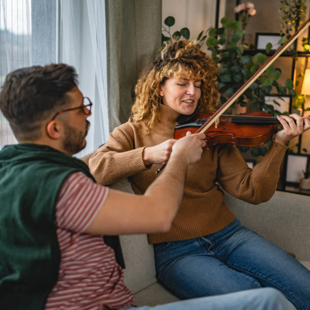 istock boyfriend teach girlfriend how to play violin practice at home 2190441348