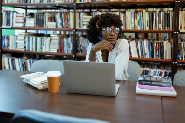 istock Young Black Woman Lost in Thought in Library 2190441383