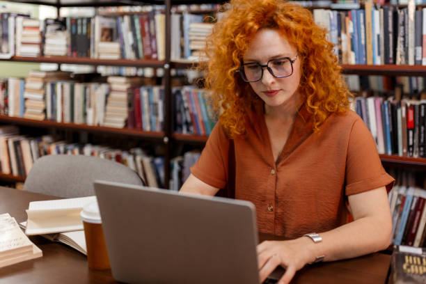 istock Focused Female Student Working on Laptop in Library 2190441440