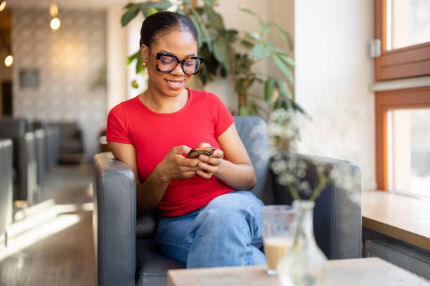 Smiling Woman Using Smartphone in a Cafe
