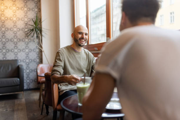 Bald Man Enjoying a Drink by Cafe Window