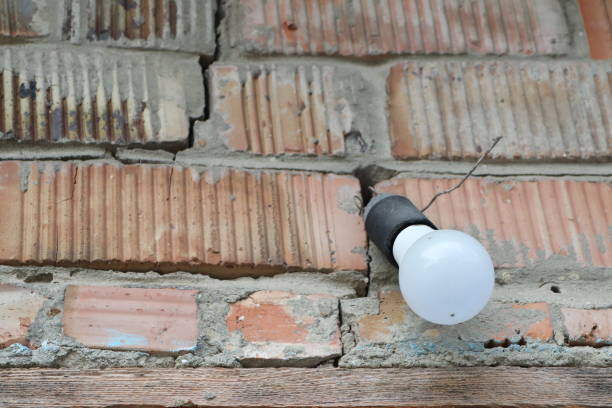 A simple lightbulb elegantly mounted on a textured brick wall showcases rustic charm and practical functionality