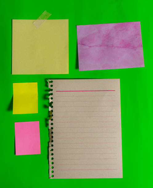 istock Different blank note papers of different sizes, colors and shapes on a green surface. 2190443429