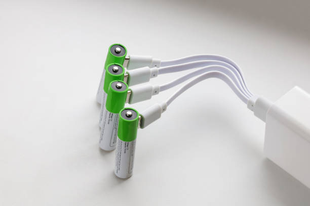 istock Four rechargeable AAA batteries with plugged in USB plug charging wires in power adapter, close-up on white textured surface 2190444686