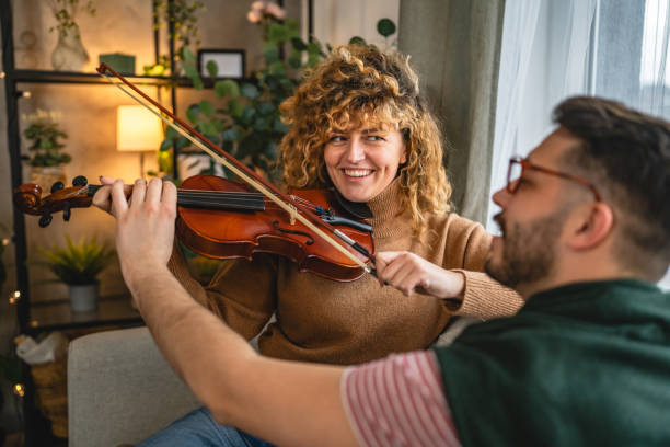 istock boyfriend teach girlfriend how to play violin practice at home 2190446873