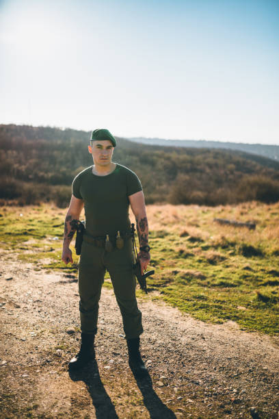 istock Armed Soldier in Tactical Gear Standing in an Open Field 2190447215