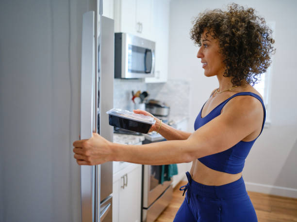 istock Woman Warming a Ready-to-Eat Meal in a Home Kitchen 2190447796