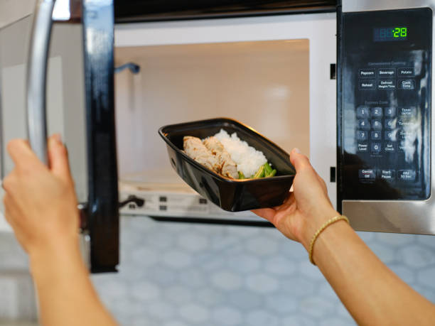 istock Woman Warming a Ready-to-Eat Meal in a Home Kitchen 2190447832