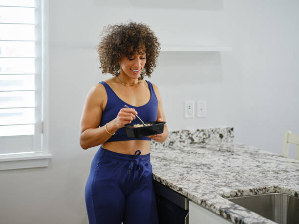 istock Woman Warming a Ready-to-Eat Meal in a Home Kitchen 2190447887