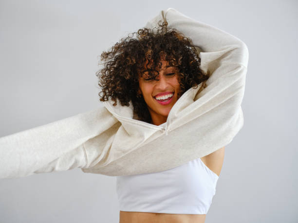 Athletic Woman Putting on a Sweatshirt