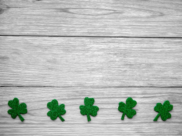 istock St. Patrick's day. Shiny Shamrock, clover leaf on a light wooden background. design with the ability to copy. a holiday in Ireland. 2190448820