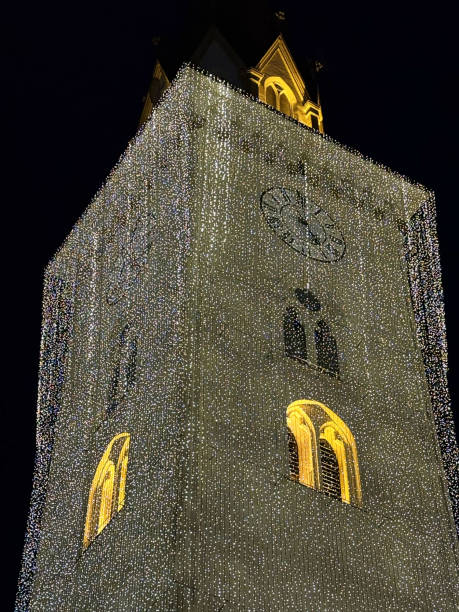 istock Illuminated clock tower at night with festive lights 2190449007