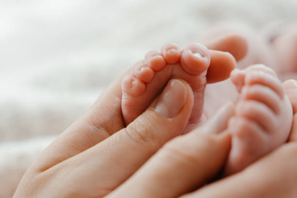 istock A newborn baby's feet in mama s hands close-up. 2190450191