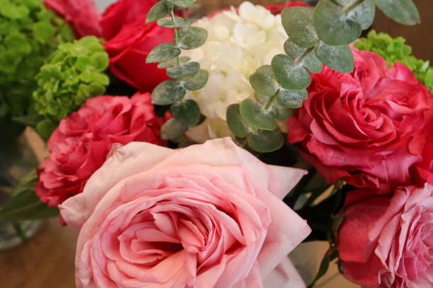 istock Soft pink and bold red roses accented by eucalyptus leaves and fresh green hydrangeas create a vibrant and elegant floral arrangement, perfect for brightening any space or celebration. 2190451327