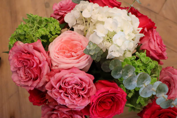 A stunning bouquet with pink, red, and blush roses, white hydrangeas, green accents, and eucalyptus leaves, creating a fresh and vibrant floral arrangement ideal for special occasions.
