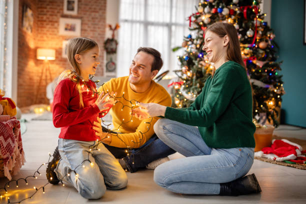 istock Family decorating for Christmas together with string lights and festive cheer 2190461663