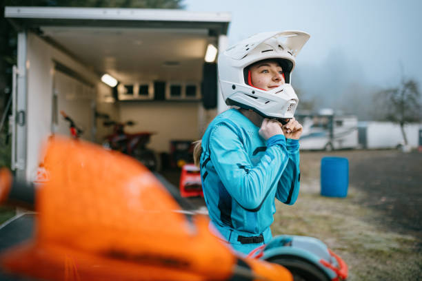 Young Woman Motocross Racing Puts on Helmet stock photo