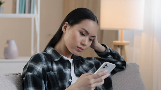 istock Asian woman has money problem online transfer payment error blocked bank account experiences trouble with e-payment. Female feels angry due lack of funds using mobile phone throwing credit card away 2190465274