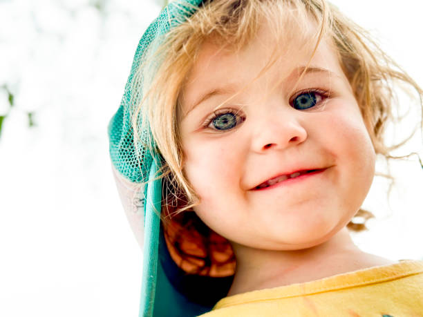 Portrait of a beautiful, happy girl with protective helmet in the park near the corporate building.
