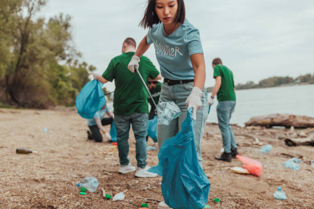 istock Volunteers cleaning a polluted river bank: teamwork and environmental protection 2190476166