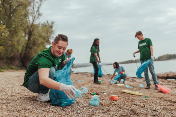 istock Volunteers collecting plastic waste on river bank: cleaning polluted beach 2190476169
