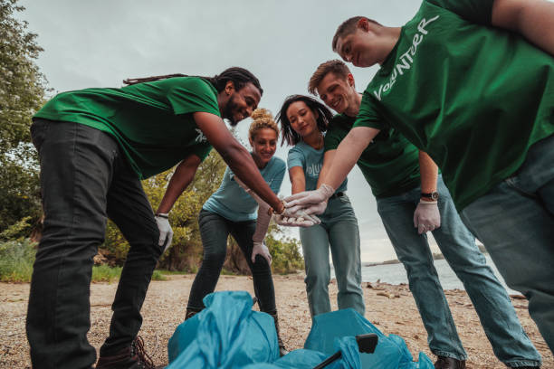 istock Volunteers joining hands before collecting waste on the beach 2190476180