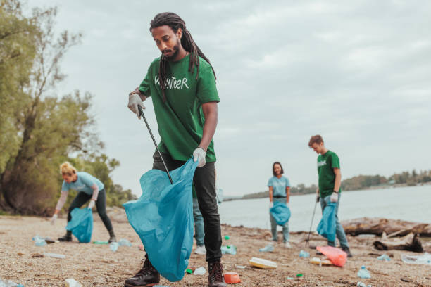 istock Volunteers cleaning a polluted beach on a cloudy day 2190476202