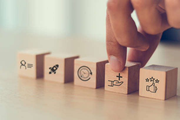 istock Value added concept. Way to adding value to product and service. Wooden blocks with value added icons. Improving products, excellent service, expert advice, consistently upgrade, deliver fast. 2190476795