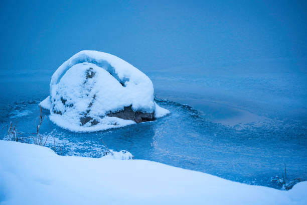 Detail of a snowy rock on the frozen shore of Pine Lake in Kluane National Park at dawn, Haines Junction,  Yukon, Canada