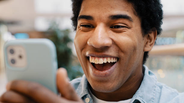 istock Close up African guy surprised by message received wins online bets looking at mobile phone opens mouth in surprise delighted shock man feels happiness from unexpected news amazing offer opportunity 2190478768