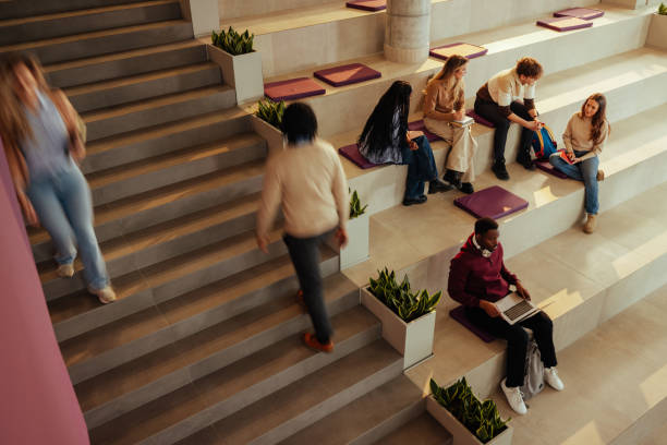 University students studying and walking in modern building hall