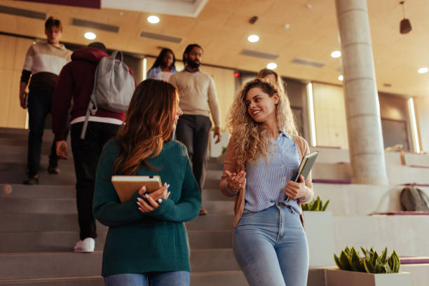 istock University students walking and talking on stairs in modern building 2190479034