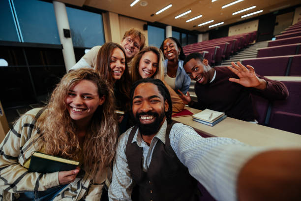 istock Happy university students taking a photo of themselves in lecture hall 2190479044