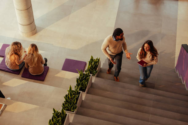 istock University students and teacher discussing on stairs in modern building 2190479852