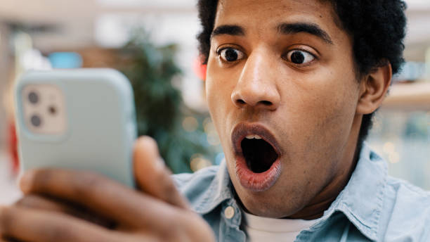 istock African american guy surprised by message received wins online bets looking at mobile phone opens mouth in surprise delighted shock man feels happiness from unexpected news amazing offer opportunity 2190480133