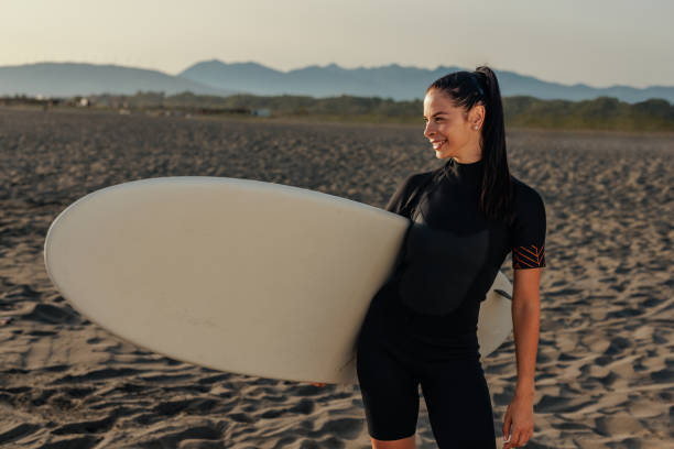 istock Athletic girl holding a surfboard at the beach 2190480344