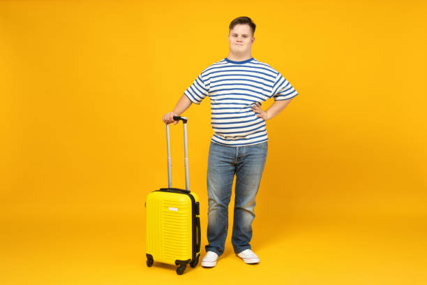 istock Smiling young man with down syndrome in glasses with suitcase 2190484234