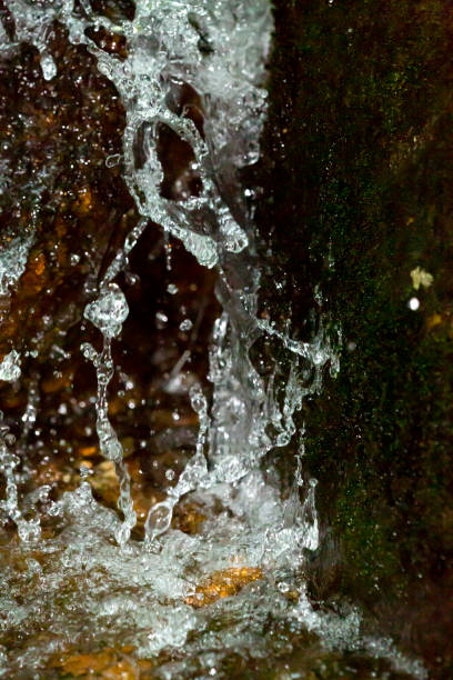 High shutter speed of 1/8,000 sec nearly stops motion, and captures strings of water drops and single beads of water in a small waterfall on Mt. Sunapee in Newbury, New Hampshire.